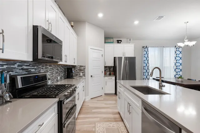a kitchen with a stove a sink and a refrigerator