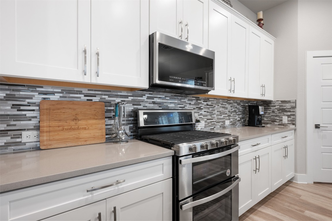 2212 Prairie Oaks Drive Georgetown, TX 78628 - Photo 22 of 39 a kitchen with granite countertop a stove microwave and sink