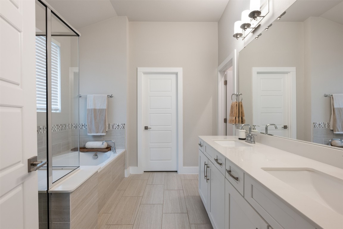 2212 Prairie Oaks Drive Georgetown, TX 78628 - Photo 26 of 39 a spacious bathroom with a granite countertop sink a mirror and shower
