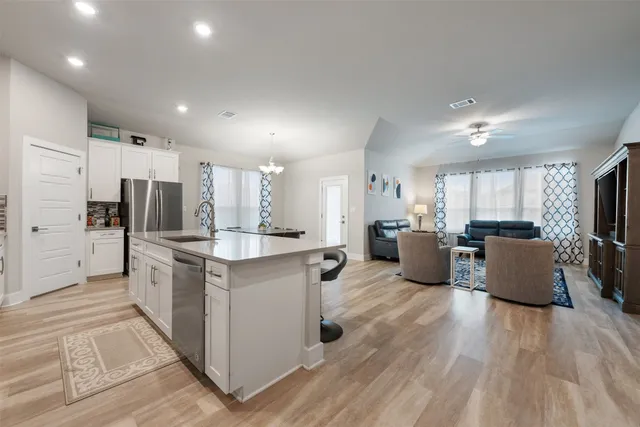 a living room with furniture a dining table and a refrigerator