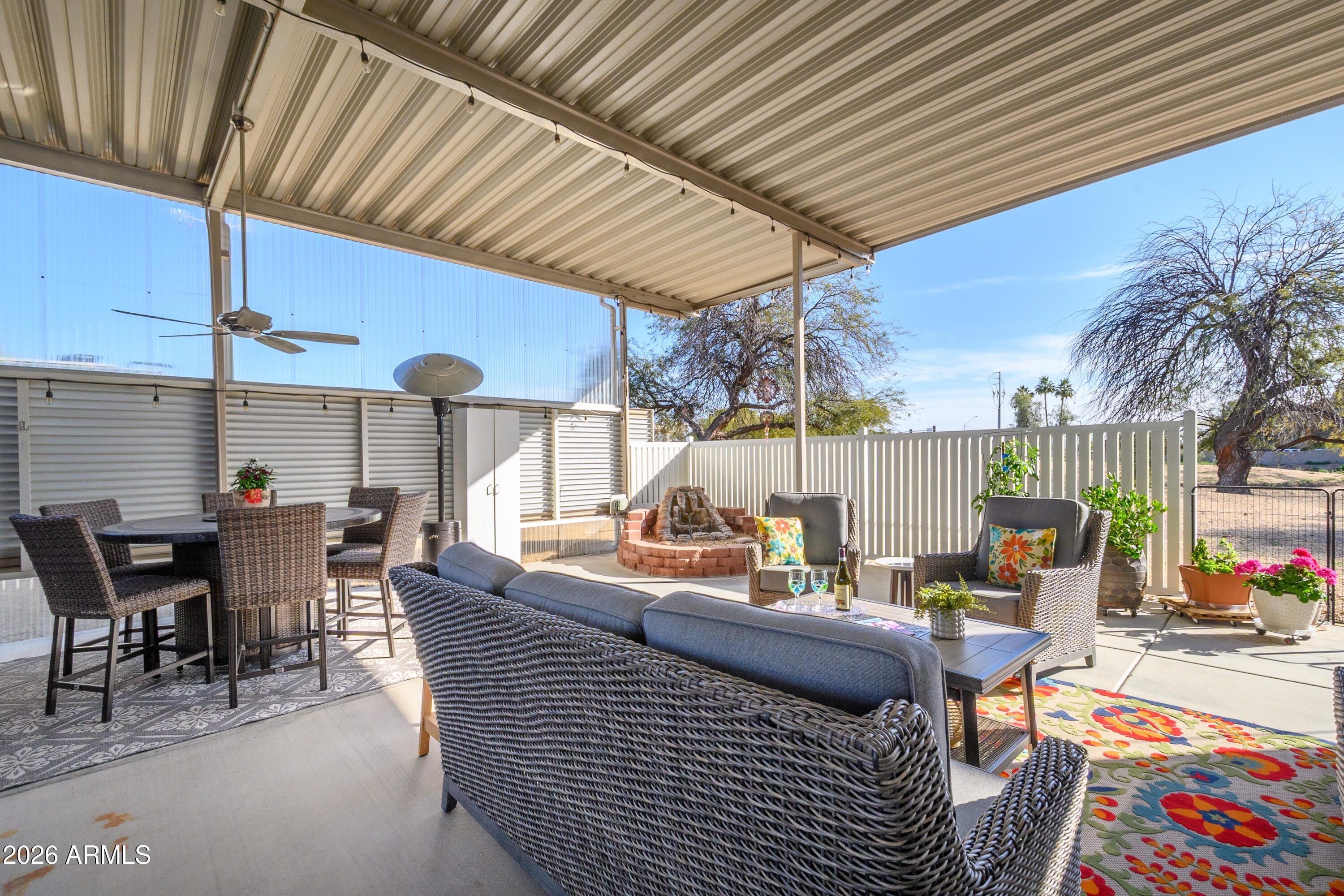 17200 West Bell Road, Unit 1052 Surprise, AZ 85374 - Photo 3 of 17 a view of a patio with dining table and chairs under an umbrella with a patio