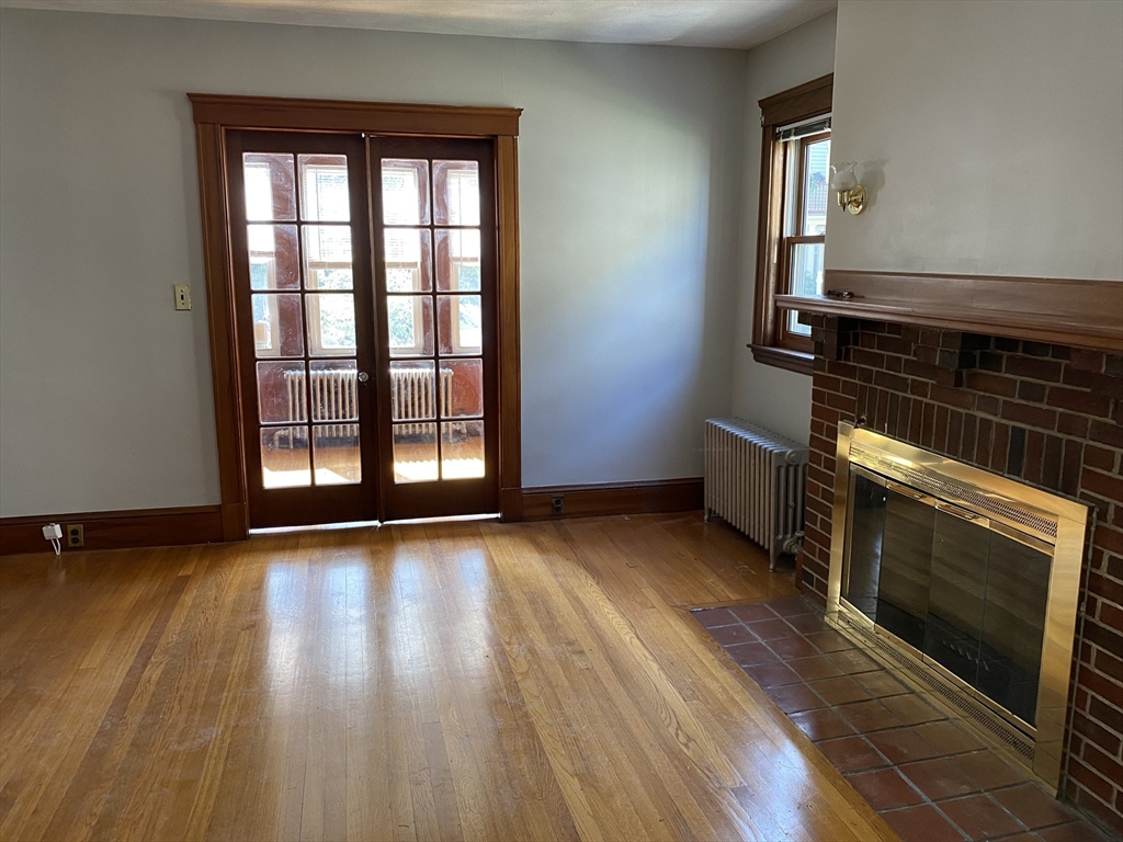 46 Grafton Street, Unit 1 Arlington, MA 02474 - Photo 2 of 12 a view of an empty room with wooden floor and a window