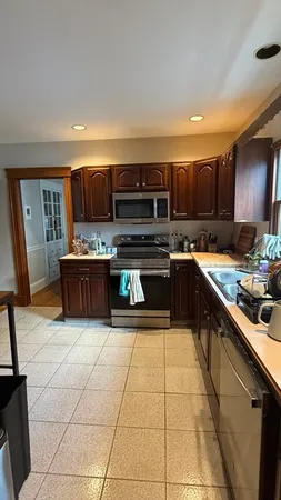 a kitchen with stainless steel appliances granite countertop a stove top oven a sink a counter space and cabinets