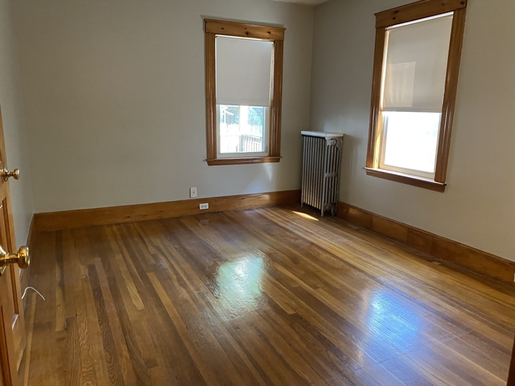 46 Grafton Street, Unit 1 Arlington, MA 02474 - Photo 10 of 12 a view of an empty room with wooden floor and a window
