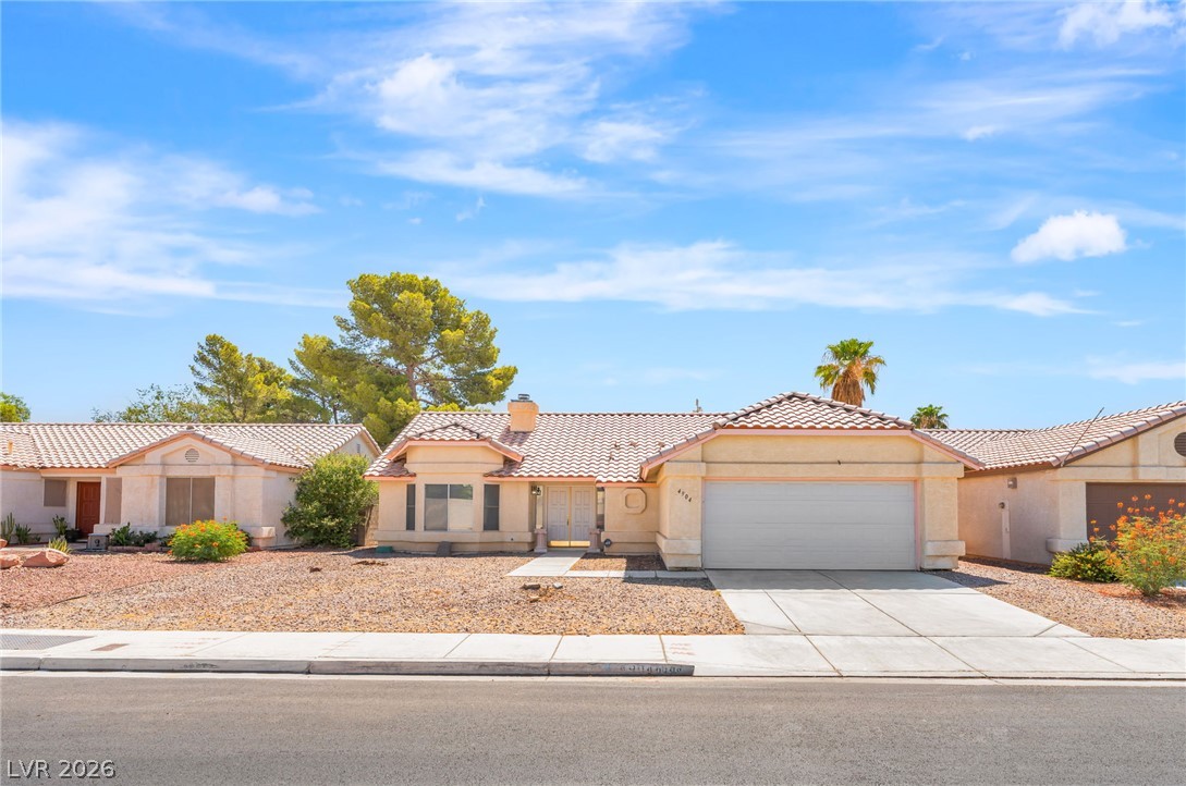 4904 Spring Falls Way North Las Vegas, NV 89031 - Photo 1 of 24 A desert-friendly facade with a tile roof and attached garage awaits.