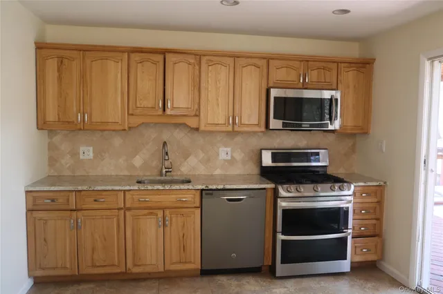 a kitchen with kitchen island a counter top space cabinets and stainless steel appliances