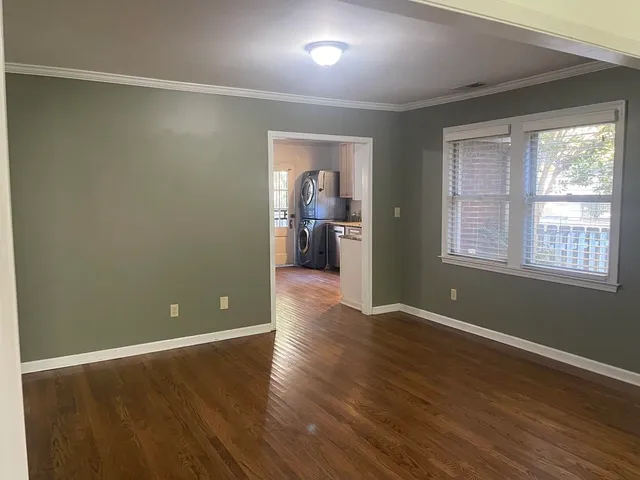 a view of a big room with wooden floor and windows