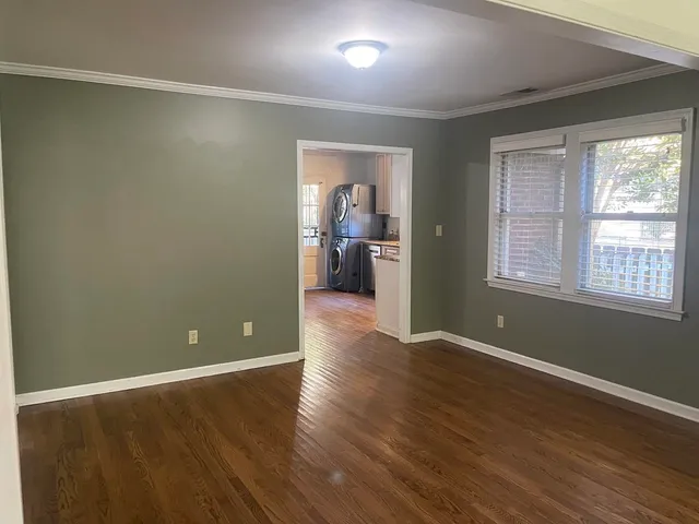 a view of a big room with wooden floor and windows