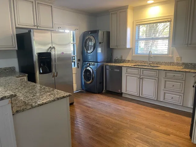a kitchen with granite countertop a refrigerator and a sink