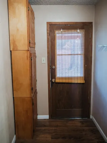 a view of empty room with wooden floor and cabinet