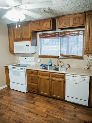 a kitchen with granite countertop a sink stainless steel appliances and cabinets