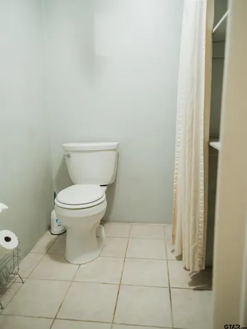 a white toilet sitting next to a shower