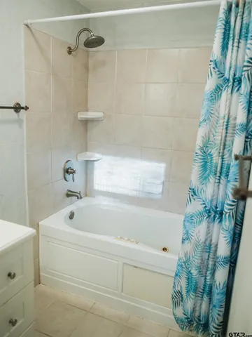 a bathroom with a bathtub and shower