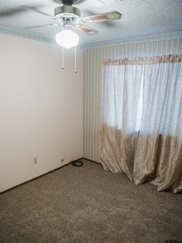 a view of a room with a window and a ceiling fan