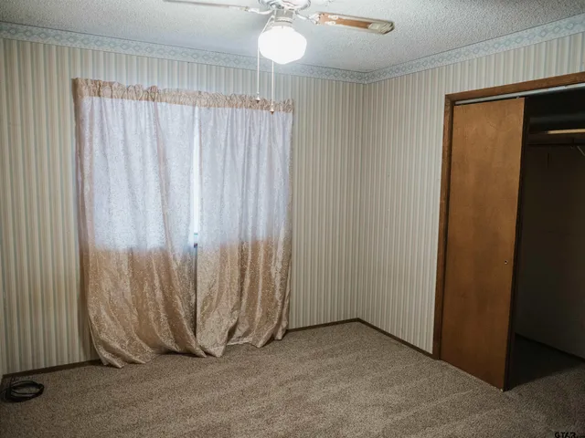an empty room with a window and a chandelier