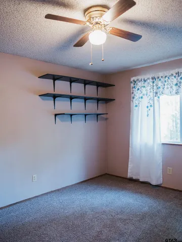 en empty room with windows and fan