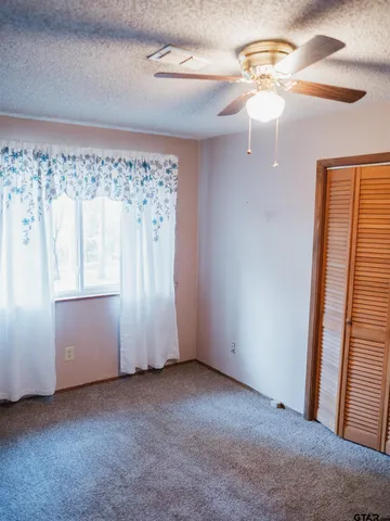 an empty room with a chandelier fan