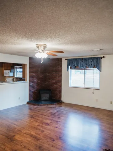 an empty room with windows and fireplace