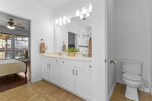 a spacious bathroom with a granite countertop sink a toilet and a mirror