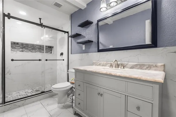 a bathroom with a granite countertop sink toilet and shower