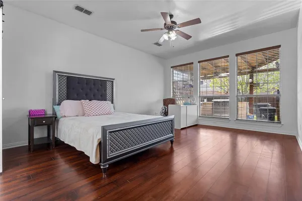 a spacious bedroom with a bed and wooden floor