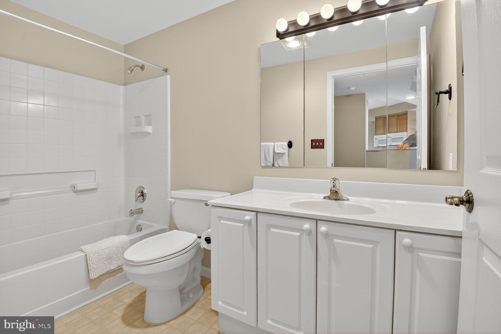 19355 Cypress Ridge Terrace, Unit 503 Leesburg, VA 20176 - Photo 12 of 22 a bathroom with a granite countertop sink toilet and shower