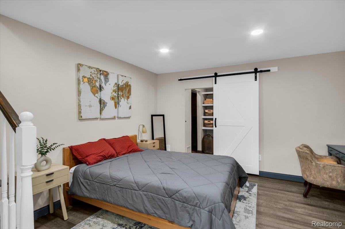 476 Touraine Road Grosse Pointe, MI 48236 - Photo 13 of 30 Recessed ceiling lighting, wood-finish flooring, white barn door, and built-in shelving