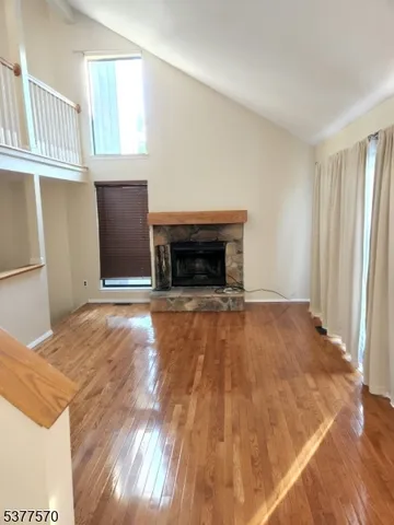 a view of empty room with wooden floor and fireplace