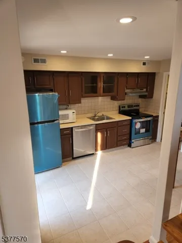 a kitchen with stainless steel appliances granite countertop a refrigerator and a stove top oven