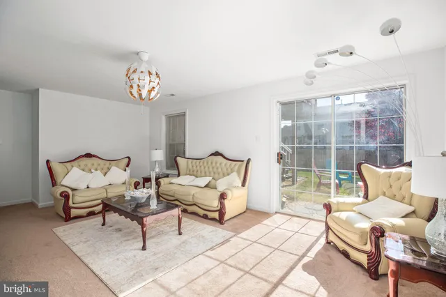 a living room with furniture a flat screen tv and a chandelier