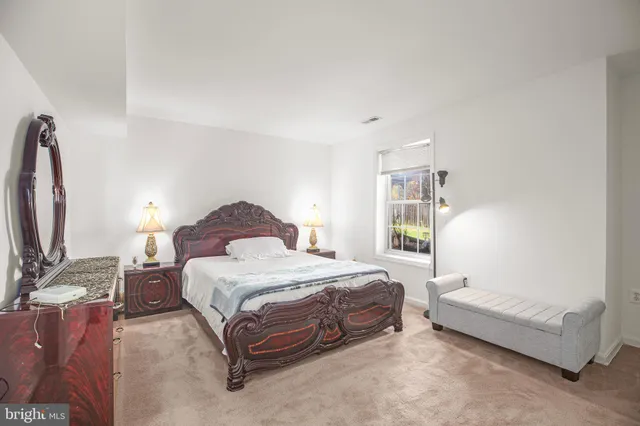 a bedroom with a bed and a dresser with mirror