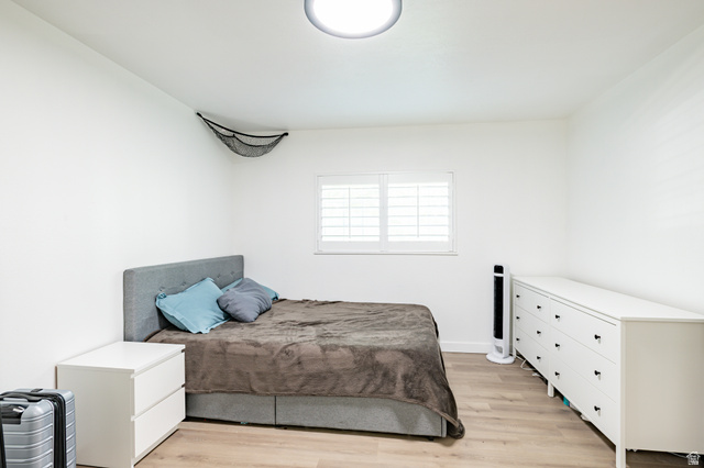 1221 Waterside Cove, Unit 11 Midvale, UT 84047 - Photo 9 of 23 Bedroom featuring light wood-finish flooring and a window with white plantation shutters