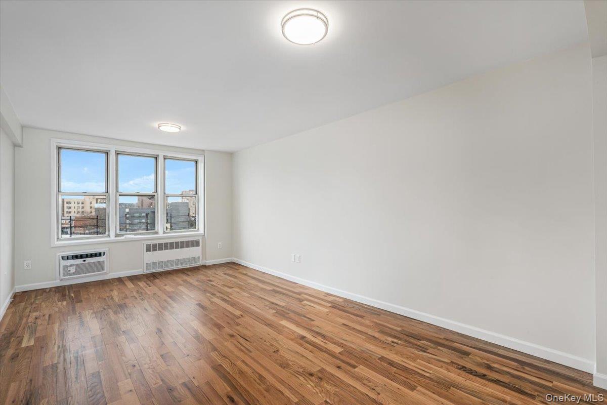 59-30 108th Street, Unit 6D Queens, NY 11368 - Photo 11 of 23 a view of an empty room with a window and wooden floor