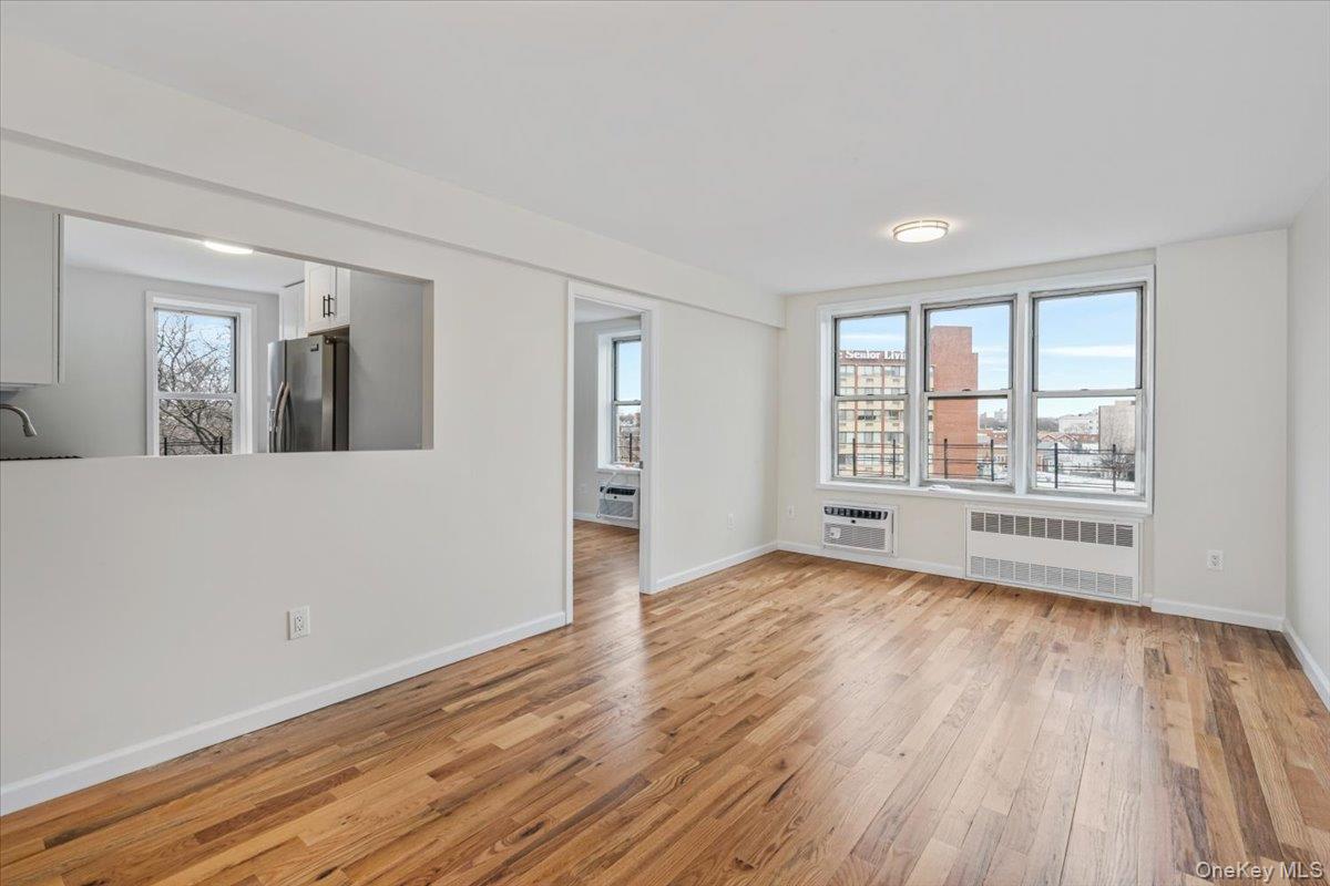 59-30 108th Street, Unit 6D Queens, NY 11368 - Photo 12 of 23 wooden floor in an empty room with a window