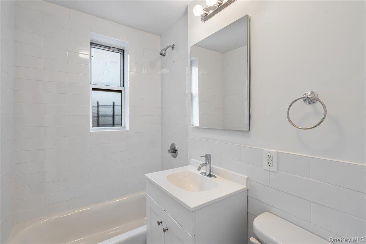 59-30 108th Street, Unit 6D Queens, NY 11368 - Photo 18 of 23 a bathroom with a toilet sink and mirror