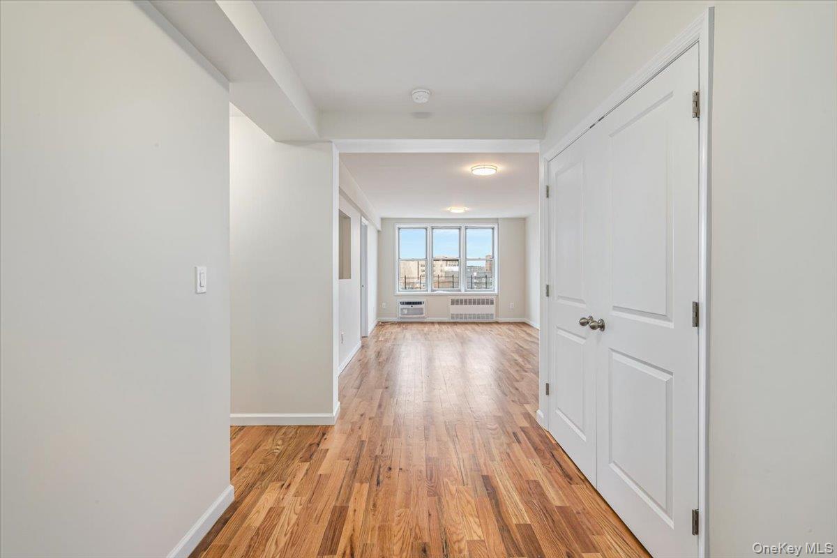 59-30 108th Street, Unit 6D Queens, NY 11368 - Photo 9 of 23 a view of a hallway with wooden floor and a living room