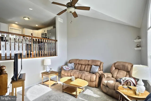 a view of a hallway with couches and a dining table