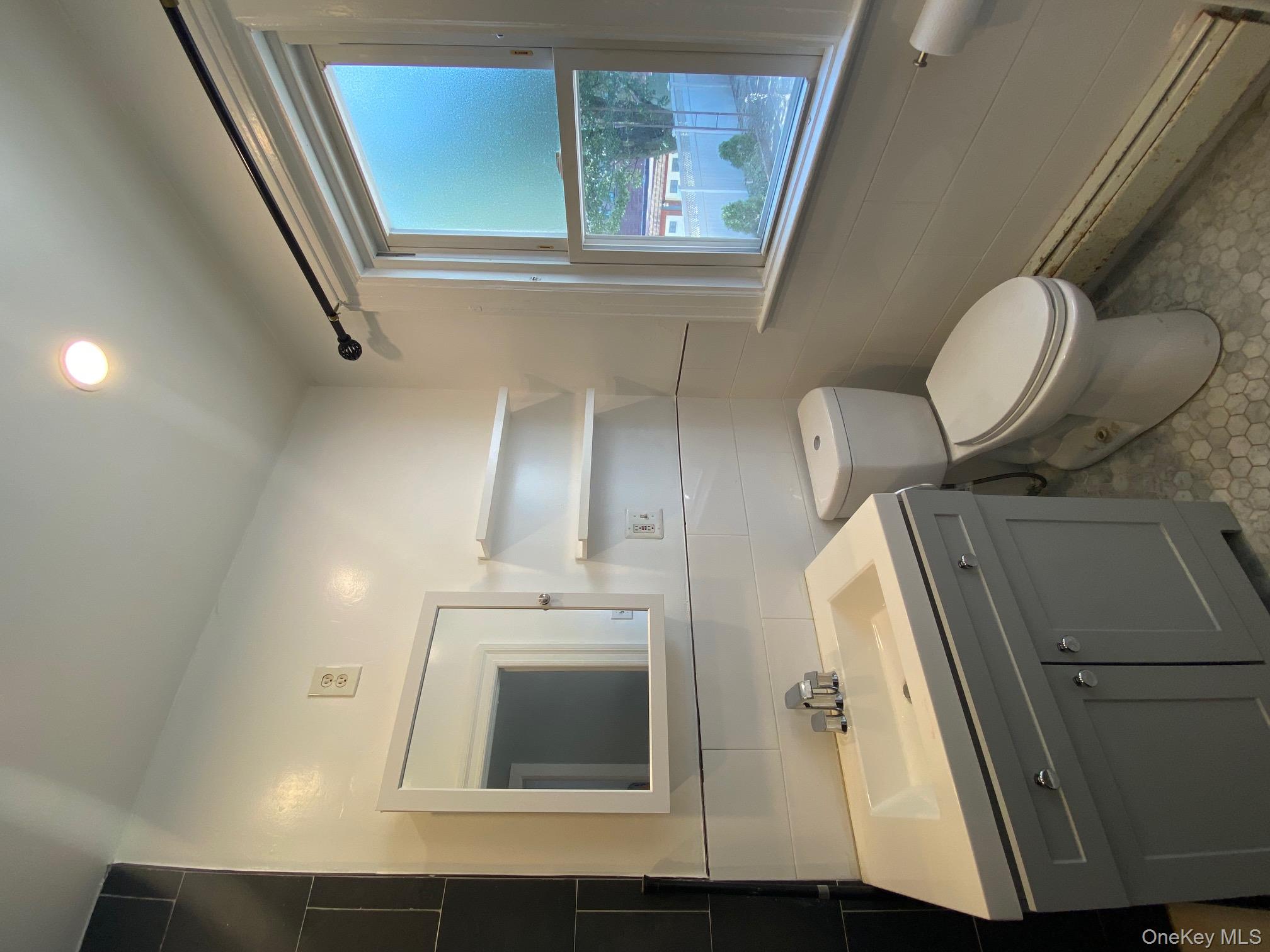 686 East 239th Street Bronx, NY 10470 - Photo 12 of 30 a bathroom with a toilet sink and mirror