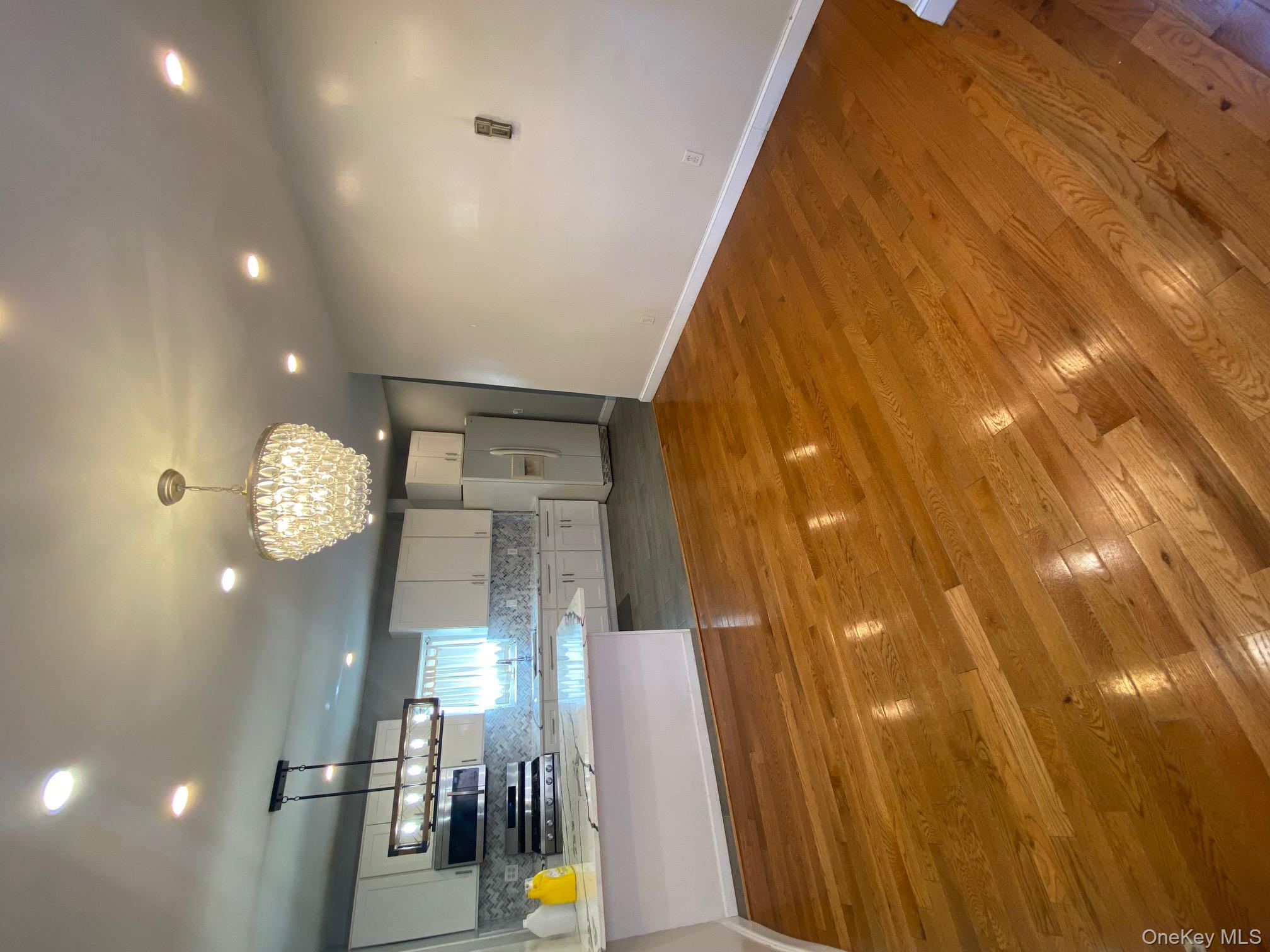 686 East 239th Street Bronx, NY 10470 - Photo 7 of 30 a view of a room with kitchen island stainless steel appliances wooden floor and window