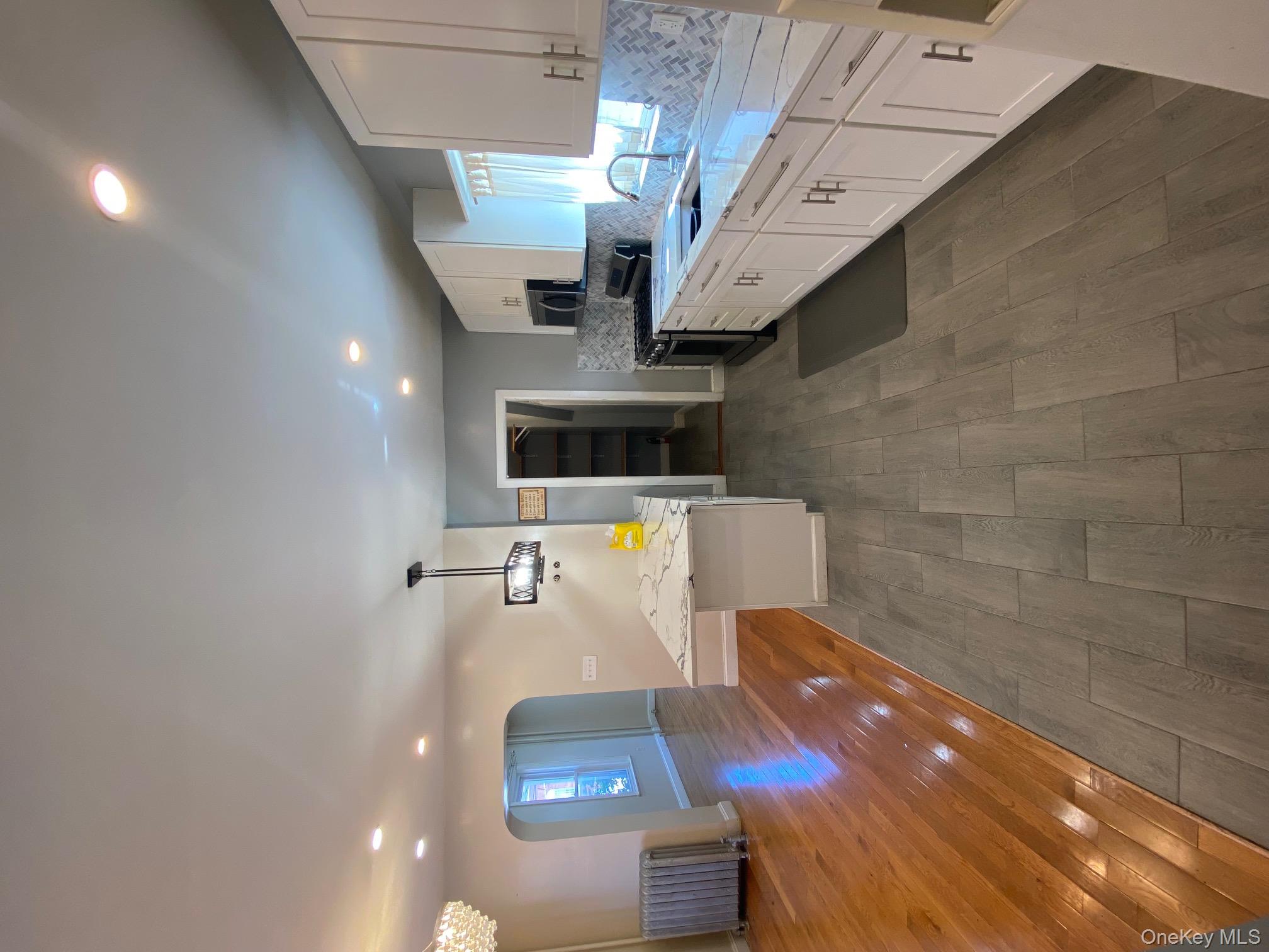 686 East 239th Street Bronx, NY 10470 - Photo 8 of 30 a large kitchen with stainless steel appliances lots of counter space and wooden floor