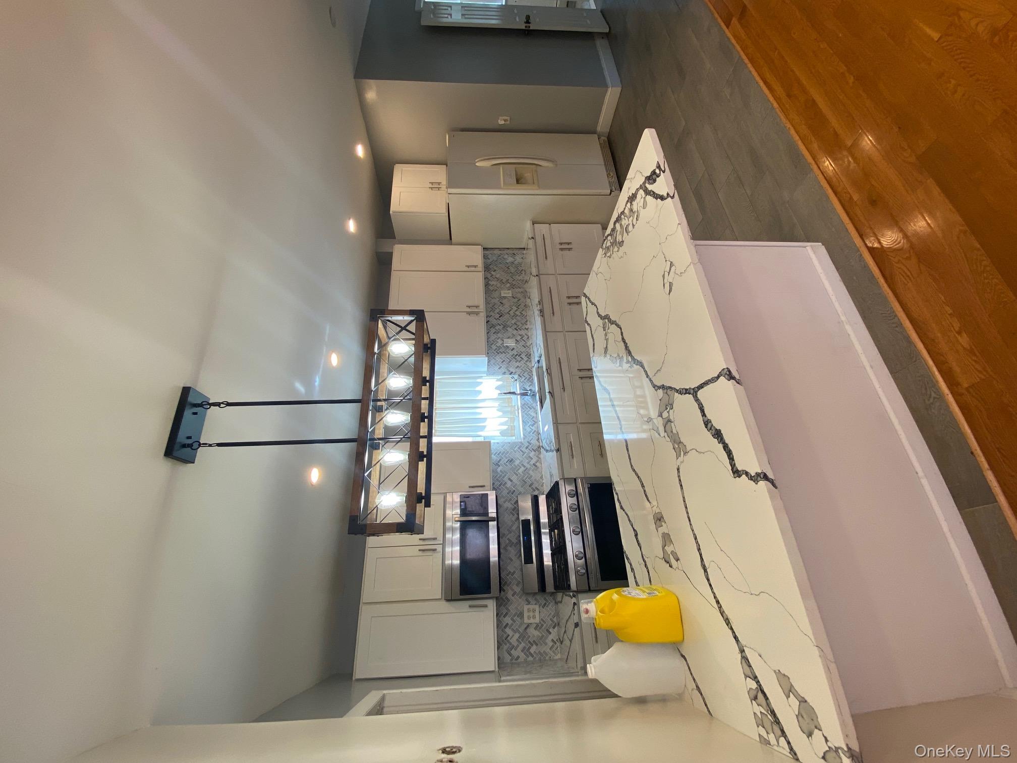 686 East 239th Street Bronx, NY 10470 - Photo 9 of 30 a kitchen with stainless steel appliances kitchen island granite countertop a sink a stove counter space and cabinets