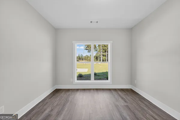 an empty room with wooden floor and window