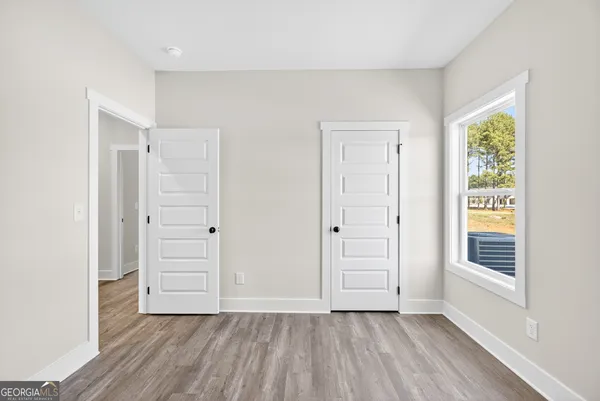 an empty room with windows and closet