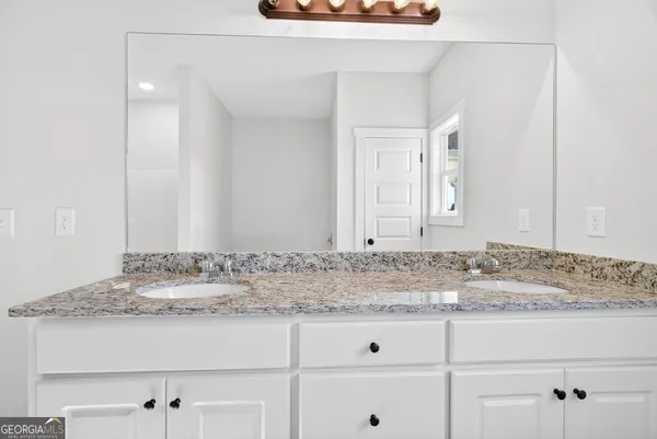 a bathroom with a granite countertop sink and vanity