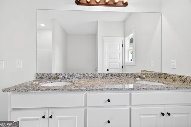 a bathroom with a granite countertop sink and vanity