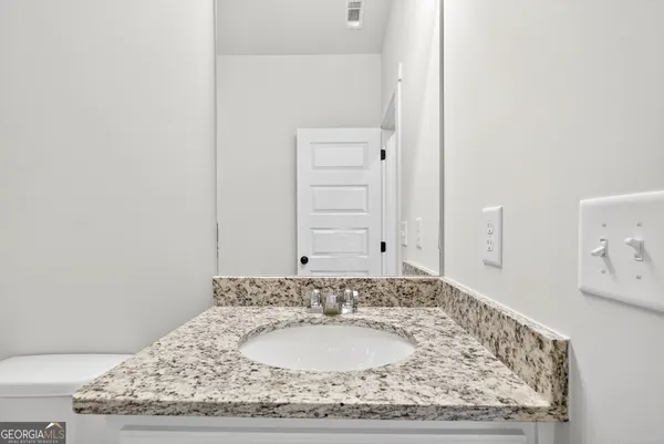 a bathroom with a granite countertop sink and a mirror