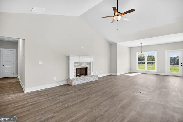 a view of an empty room with a fireplace and a window