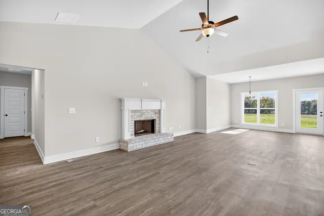 a view of an empty room with a fireplace and a window