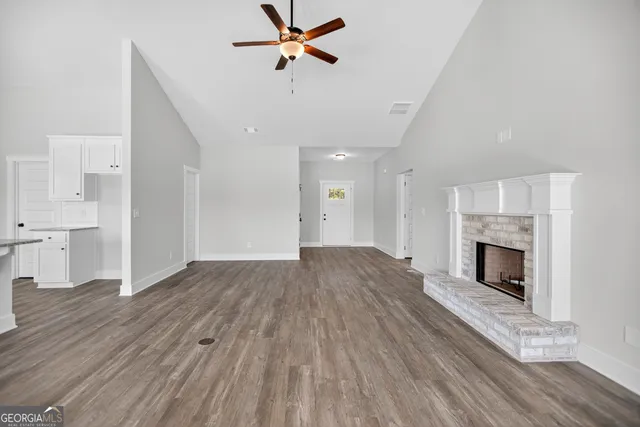 a view of empty room with wooden floor and fireplace