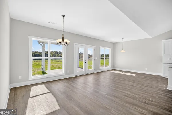a view of an empty room with a window and wooden floor